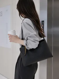 Sac hobo épaule aisselle en texture cuir noir pour femme, style de banlieue élégant.