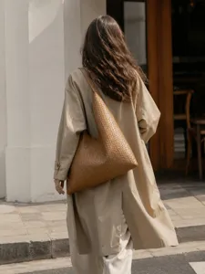 Detailed shot of brown woven leather shoulder bag, stylish vintage underarm bag design.