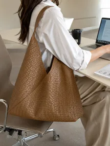 Detailed lifestyle view of a stylish brown woven leather hobo shoulder bag in office.