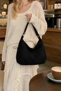Casual black nylon shoulder bag detail view, showing soft hobo design and durable fabric.