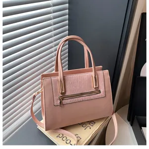 Close-up detail of the pink women handbag featuring crocodile pattern pocket and metal zippers.
