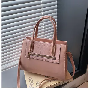 Pink PU leather handbag detail showing crocodile pattern front pocket and gold hardware accents.