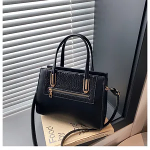Elegant black handbag with chic crocodile texture panel, gold-tone hardware, and versatile straps.
