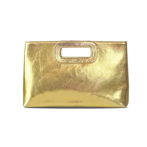 Gold metallic PU handbag detail close up showing textured leather surface and handle.
