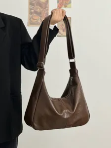 Detail view of retro brown soft leather shoulder bag showing slouchy hobo design.