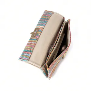 Detailed top view of colorful woven straw shoulder bag interior compartments and turn lock.