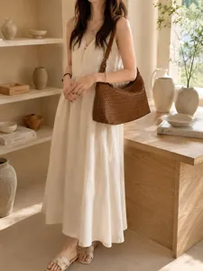 Detailed view of the stylish brown woven leather shoulder bag in a warm aesthetic interior scene.