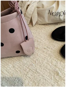 Pink polka dot underarm bag for women, casual chic shoulder handbag with drawstring.