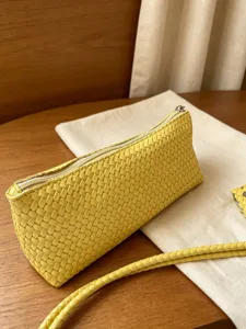 Woven leather zipper pouch detailed view, premium yellow compact clutch bag for women.