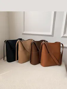 Minimalist PU leather bucket bag with large capacity, trendy shoulder and crossbody design.