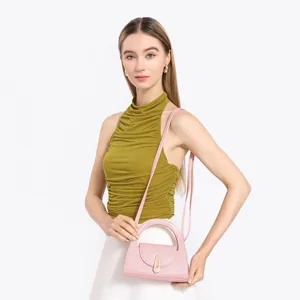 Close-up detail of the pink leather semi-circular handbag with metal lock and strap.