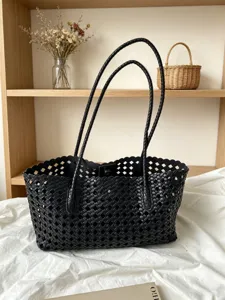 Black woven leather tote bag with long straps and scalloped edge for women daily commute.