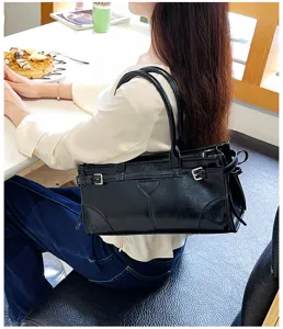Black glossy leather shoulder handbag with stylish metal buckles and elegant daily commute design.
