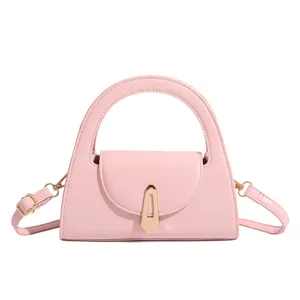 Pink top handle crossbody bag detail close up view, elegant vintage lock women purse style.