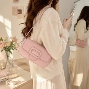 Close-up detail of the stylish pink shoulder bag showcasing the elegant buckle and smooth leather.