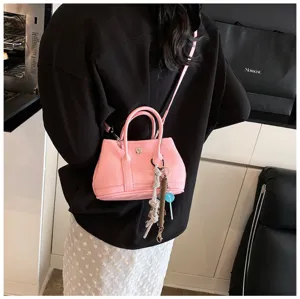 Pink mini handbag tote shoulder crossbody bag with top handles and cute charms for women.