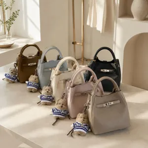 Vue détaillée du sac à main élégant doté d'une serrure métallique et joli charm d'ours.