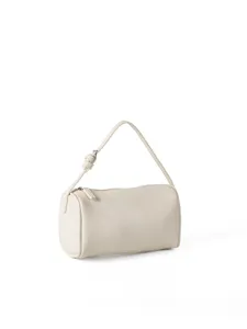 Close-up detail of the minimalist cylindrical shoulder bag texture and fine zipper puller.