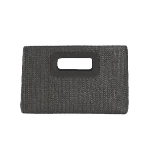 Detail view of dark grey woven straw clutch bag, showing texture and cutout handle design.
