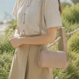 Minimalist leather cylindrical crossbody bag detail shot, elegant daily wear accessory.