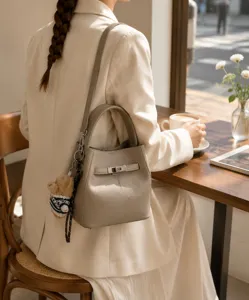 Vue detaillee du sac seau en cuir elegant avec fermoir en metal chic et pendentif charmant.