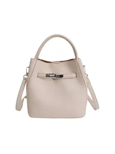 Sac seau élégant en cuir beige pour femme, sac à bandoulière tendance avec poignée et serrure.