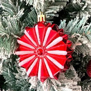 Roter facettierter Christbaumschmuck mit gefrosteten Streifen für festliche Feiertagsdeko.