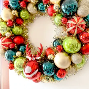 Detailansicht des Weihnachtskranzes dekoriert mit bunten Kugeln und einem Rentier-Anhänger.