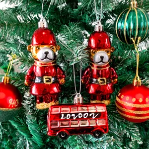 Detailansicht von Christbaumkugeln mit süßen Bären und rotem Bus für die Weihnachtsdeko.