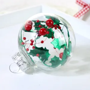 Transparente Christbaumkugel aus Kunststoff mit roten Beeren und grünen Stechpalmenblättern.