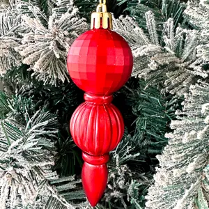Detaillierte Nahaufnahme eines roten galvanisierten Kunststoff Christbaumschmucks am Ast.