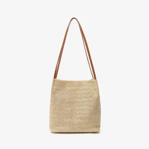 Chique stro geweven emmertas voor dames met elegante bruine schouderbanden, zomerse stijl.
