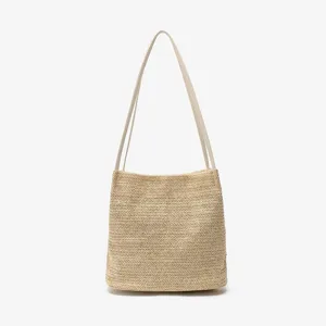 Stijlvolle strooien emmertas voor dames met een chique geweven ontwerp en slanke bandjes.