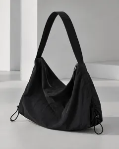 Close-up detail of the black nylon hobo shoulder bag showing zipper and adjustable sides.