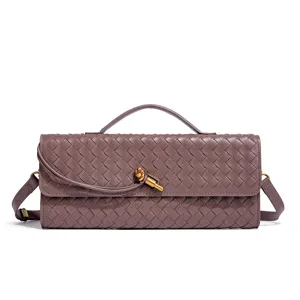 Close-up of the woven leather baguette bag showcasing intricate intrecciato texture and metal knot.