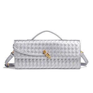 Silver woven leather shoulder bag with gold knot hardware, elegant baguette clutch for women.
