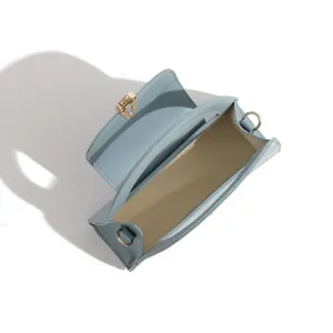 Top view detail of light blue semi-circular women handbag with retro lock and strap rings.