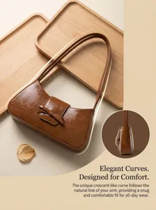 Detailed view of the brown leather baguette bag highlighting its elegant bow and curved arm design.