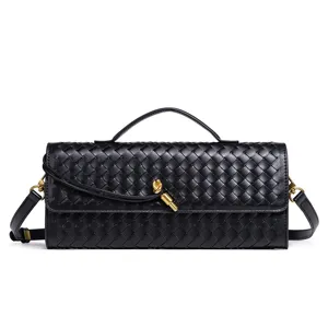 Detailed view of black woven leather handbag with metal knot closure and top handle.