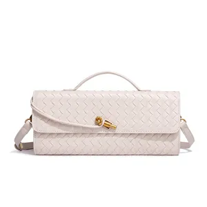 Detail view of a chic beige woven leather shoulder bag featuring a stylish gold knot closure.