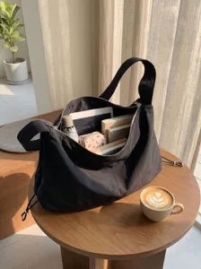 Black nylon slouchy shoulder bag detail, large capacity commuter tote with zipper and drawstring.