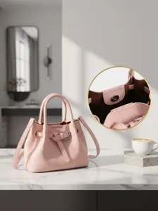 Pink leather handbag detail shot showing chic bucket bag design with stylish strap and clasp.