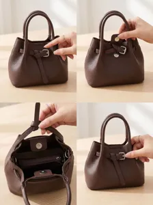 Detailed view of the brown leather commuter bucket bag showing buckle and magnetic clasp.