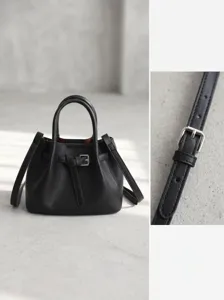 Chic black leather bucket handbag detail showcasing elegant buckle strap and premium texture.