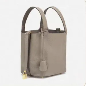 Detail shot of grey pu bucket handbag, classic padlock design, minimalist daily tote accessory.