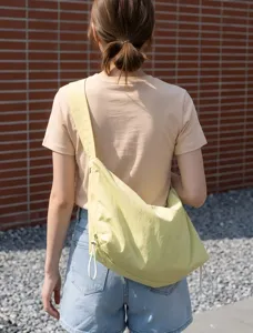 Casual yellow nylon crossbody bag worn by model, showing casual daily commuting style.
