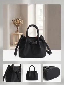 Detailed view of black leather bucket handbag showcasing belt buckle and fine texture.