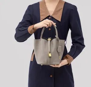 Minimalist grey PU leather bucket handbag with gold padlock detail and top handles.