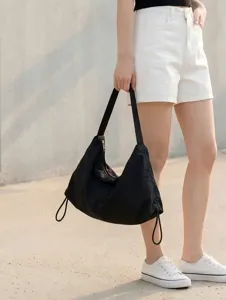 Detail view of the black nylon slouchy shoulder bag highlighting strap and drawstring style.