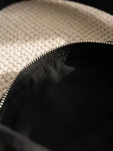 Black nylon bag detail shot showing the metal zipper and dark interior lining clearly.